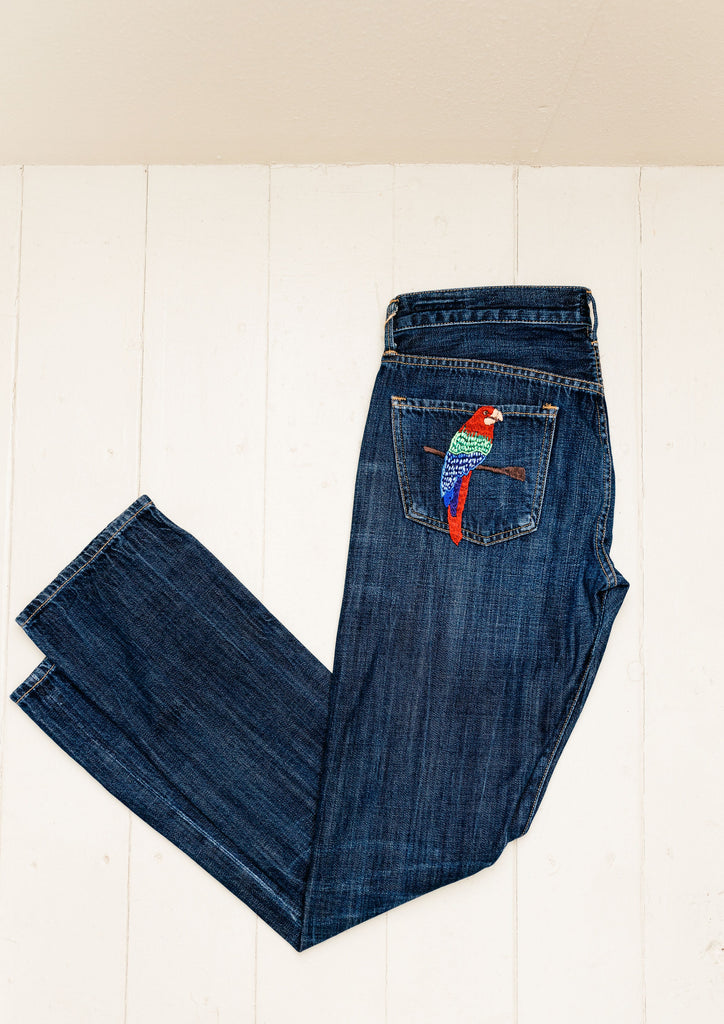 These jeans are hand-embroidered by a group of talented makers in Guatemala using traditional techniques. The back pocket of the jeans features a colorful embroidered parrot. 