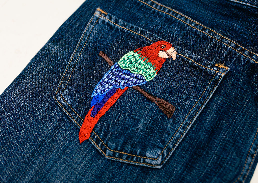 These jeans are hand-embroidered by a group of talented makers in Guatemala using traditional techniques. The back pocket of the jeans features a colorful embroidered parrot. 